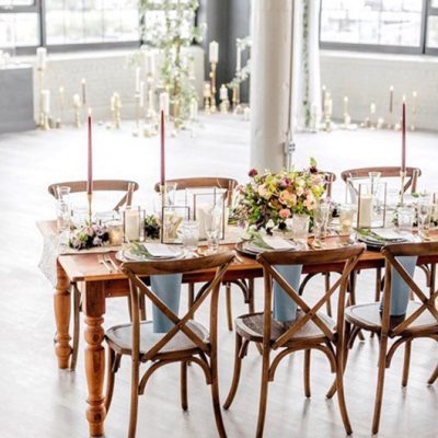 cropped farm table and cross back chairs in industrial warehouse